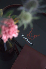 Picture of markore packaging tin box with logo and nora veldt cross body shoulder wallet sitting on a table