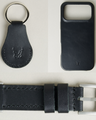 Three premium leather items for apple products in midnight black: airtag keychain with metal key ring and embossed Markore logo, iphone 17 case with embossed Markore logo and watch strap with silver stainless steel buckle and adapter.