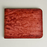 Front view of hand-painted full-grain leather bifold wallet in red, featuring handmade stitching. Markore Canvas Flame.