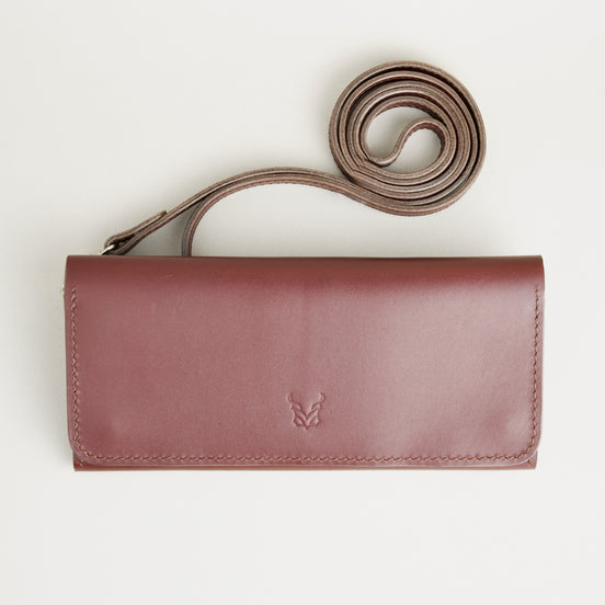 Front view of horizontal full-grain leather crossbody bag and matching shoulder strap in Espresso Brown, showing handmade stitching and embossed logo. Markore Gul Sahar.