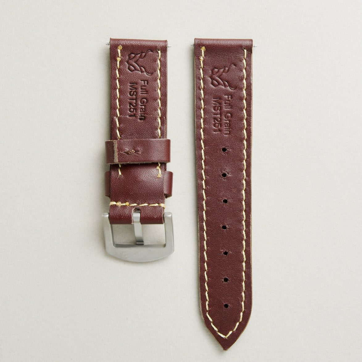 Back view of espresso brown leather strap with stainless steel buckle, showing ivory stitching, embossed logo, and serial number. Markore Hour Line.