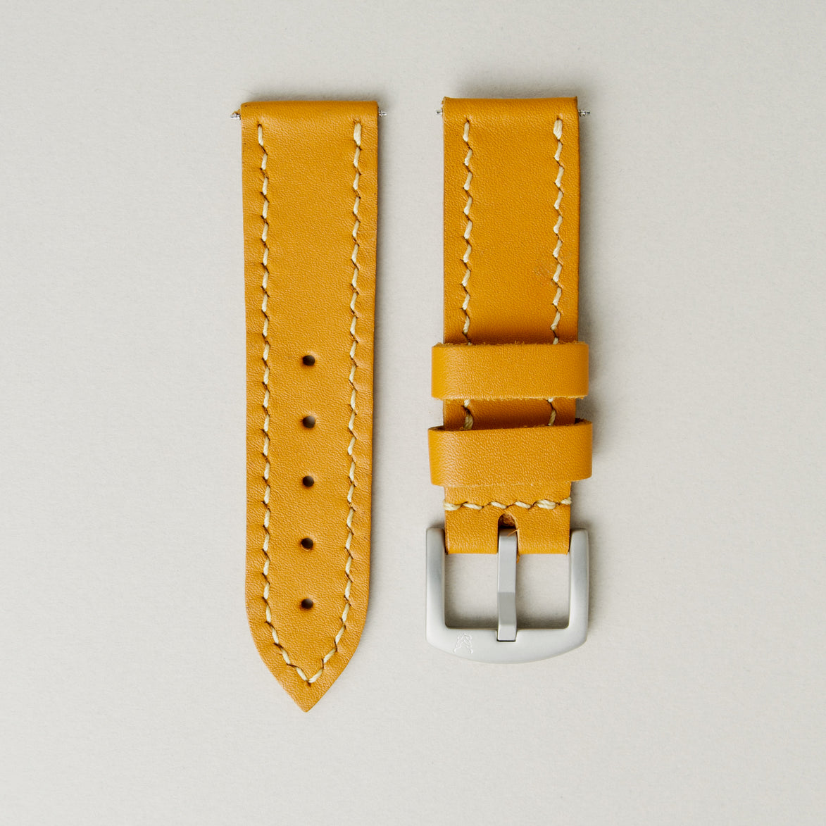 Amber full-grain leather watch strap with handmade stitching, matching leather loops, and stainless steel buckle. Markore Hour Line.