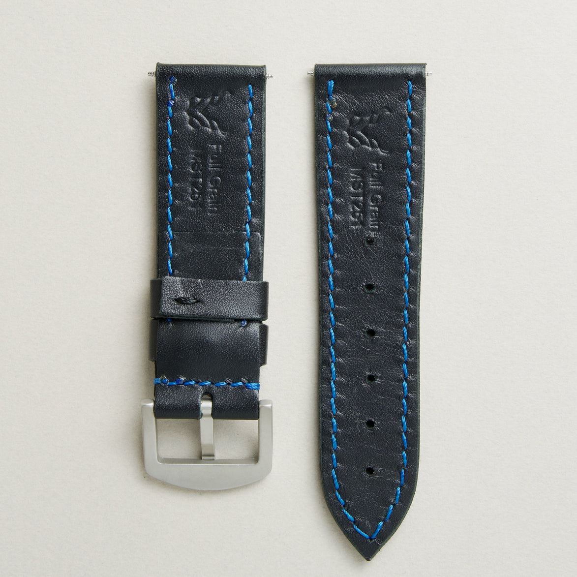 Back view of Midnight Black leather strap with stainless steel buckle, showing blue stitching, embossed logo, and serial number. Markore Hour Line.