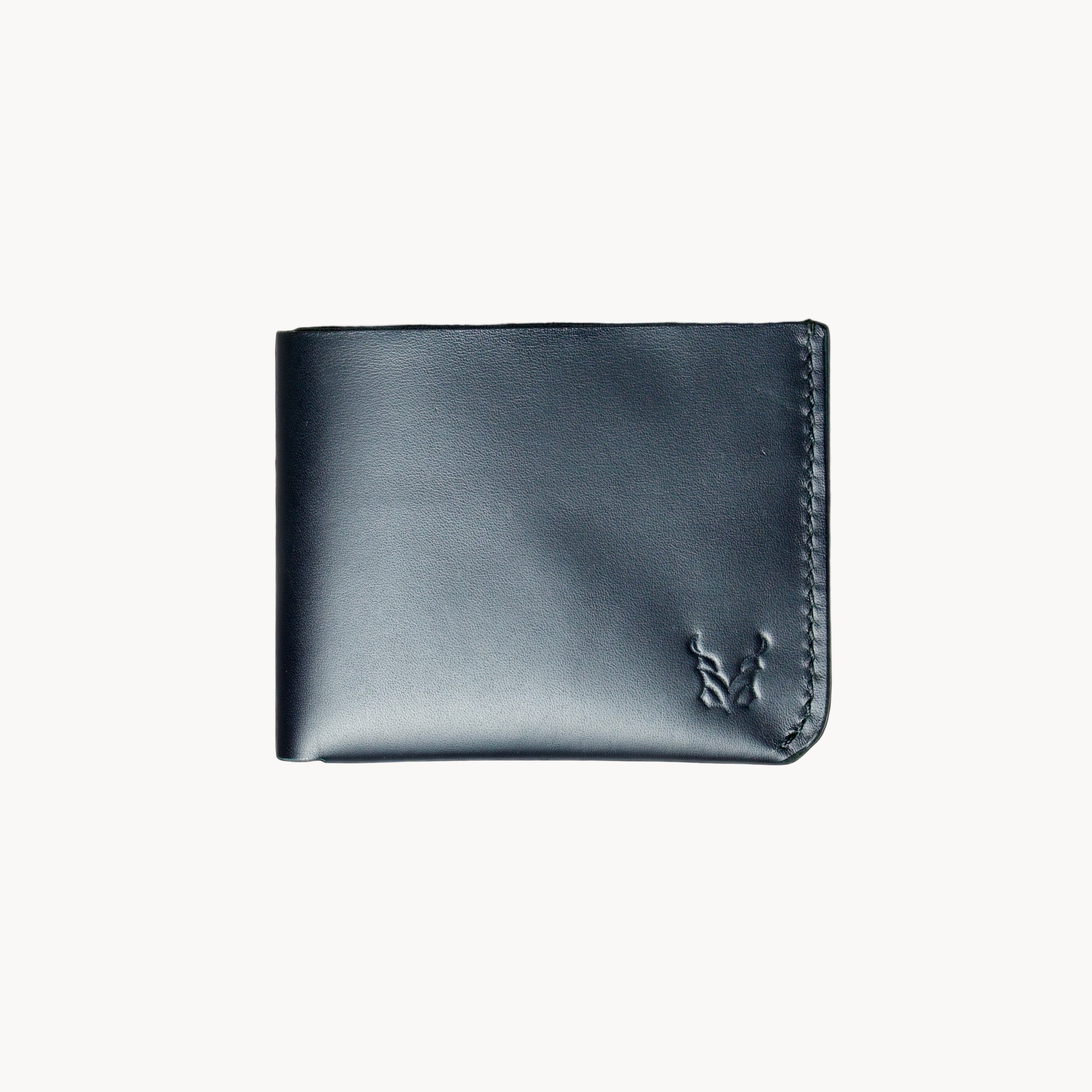 A black classic bi-fold wallet made from vegetable-tanned full-grain leather, displayed against a plain background.