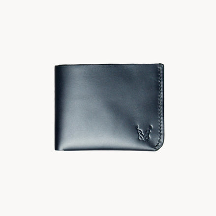 A black classic bi-fold wallet made from vegetable-tanned full-grain leather, displayed against a plain background.