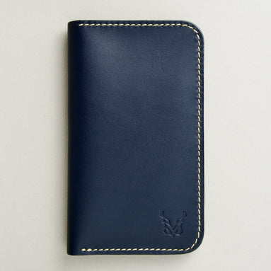 front view of vertical full-grain leather bifold wallet in dark blue, featuring handmade stitching and embossed logo. Markore Karakoram II.
