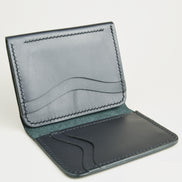 Side view of midnight black full-grain leather flap fold wallet featuring a flap closure, vertical and horizontal card slots and handmade stitching. Markore Khaas Andaz.