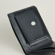 Close up of midnight black full-grain leather wallet featuring a coin pocket with stainless steel press stud and handmade stitching. Markore Assam Silk.