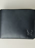 Outside view of midnight black full-grain leather wallet featuring a seamless bottom edge, handmade stitching and embossed logo. Markore Assam Silk.