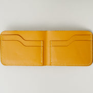 Inside view of full grain leather bifold wallet in amber, featuring ivory handmade stitching and card slots. Markore Hunza Fold.