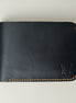 Front view of full grain leather bifold wallet in midnight black, featuring amber handmade stitching and embossed logo. Markore Hunza Fold.