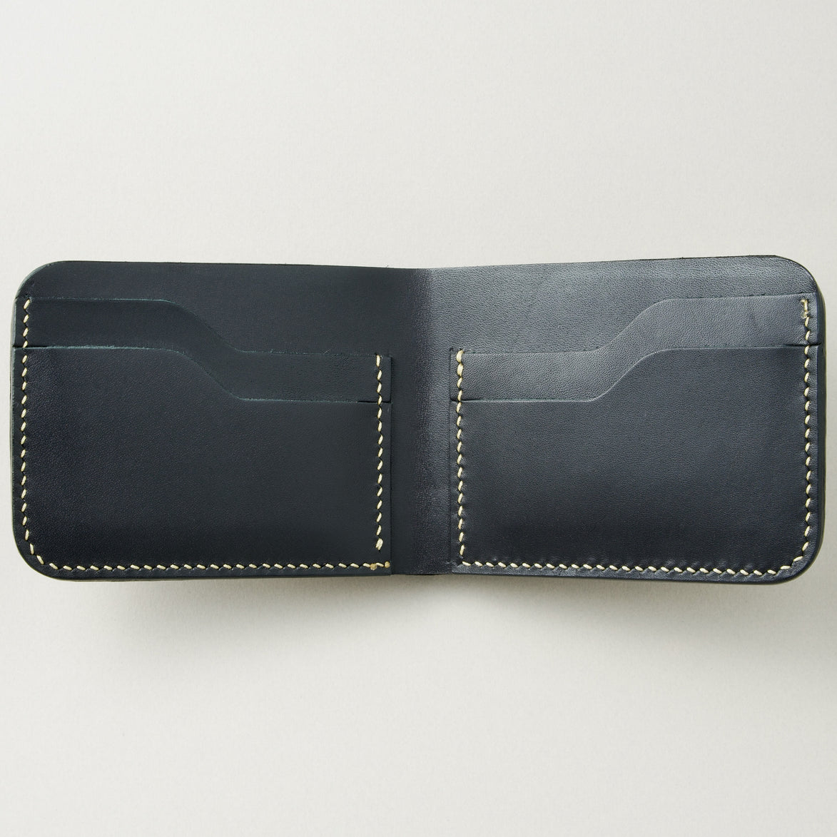 Interior view of obsidian black croc-embossed full-grain leather bifold wallet featuring ivory handmade stitching and card slots. Markore Indus Sultan