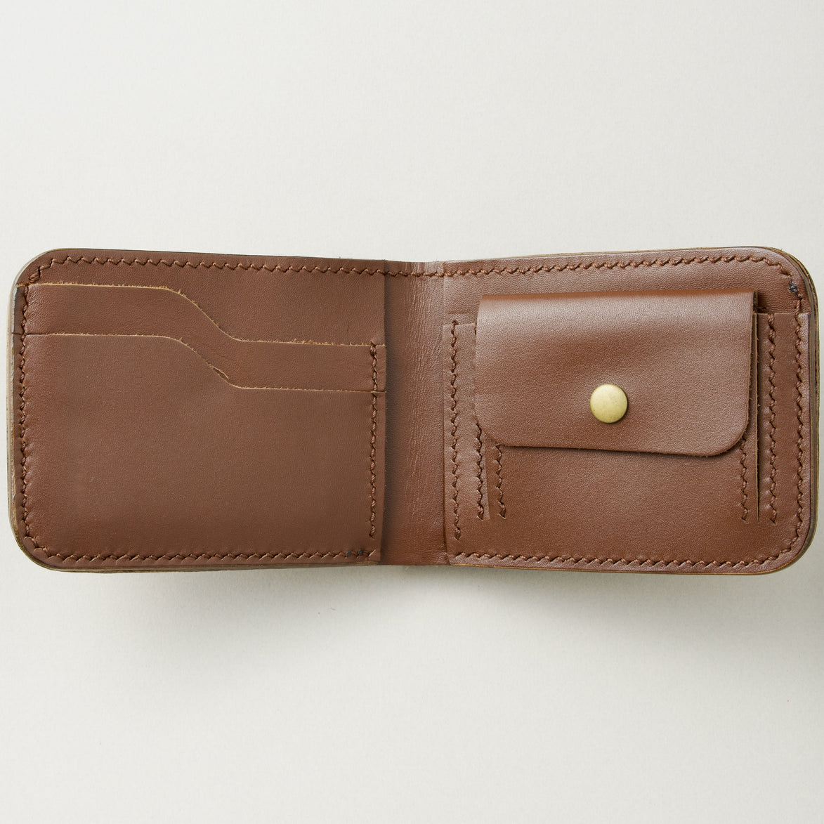 Interior view of espresso brown full-grain leather bifold wallet featuring handmade stitching and coin pocket with brass press stud. Markore Indus Sultan