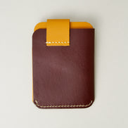 Back view of full grain leather card holder in espresso brown and amber featuring handmade stitching. Markore Niva Loop.
