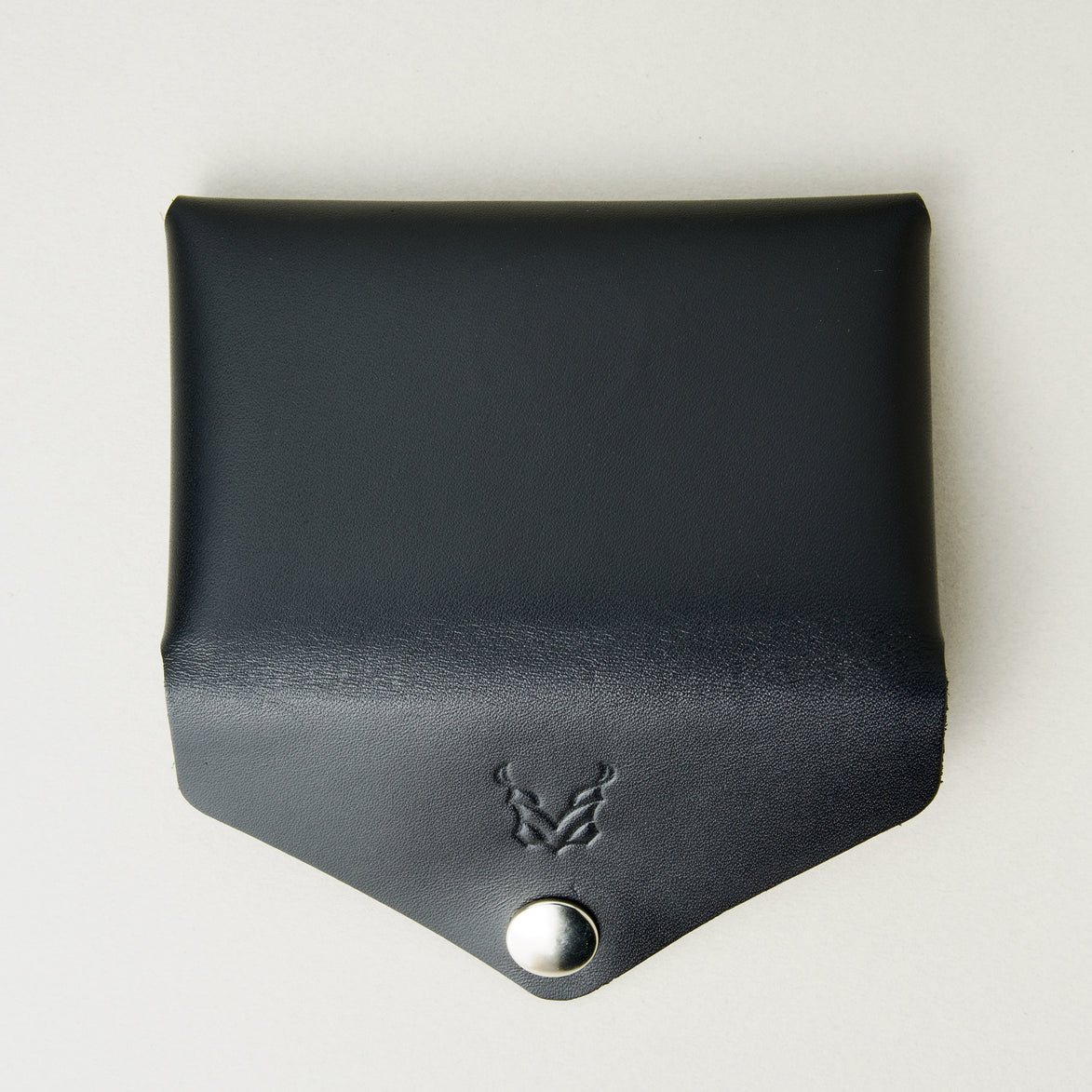 Back view of full grain leather envelope style wallet with open flap in midnight black with stainless steal press button and embossed logo. Markore Niva Seal.