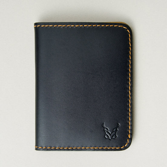 Front view of midnight black full-grain leather wallet featuring amber handmade stitching and embossed logo. Markore Ravi Fold.