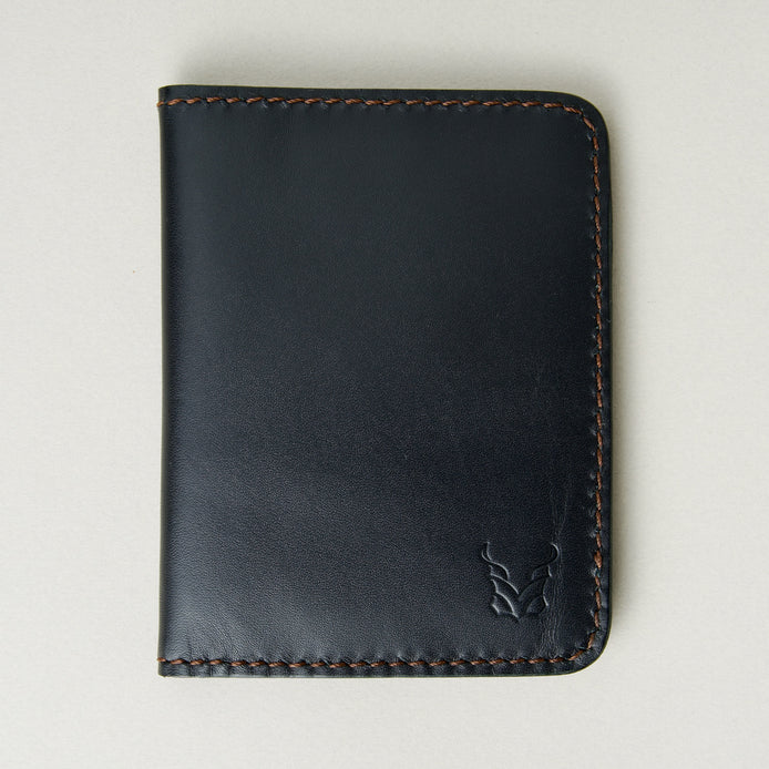 Front view of midnight black full-grain leather wallet featuring espresso brown handmade stitching and embossed logo. Markore Ravi Fold.