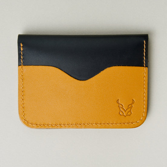 Front view of midnight black full-grain leather wallet featuring amber card slot, amber handmade stitching and embossed logo. Markore Ravi Slip.