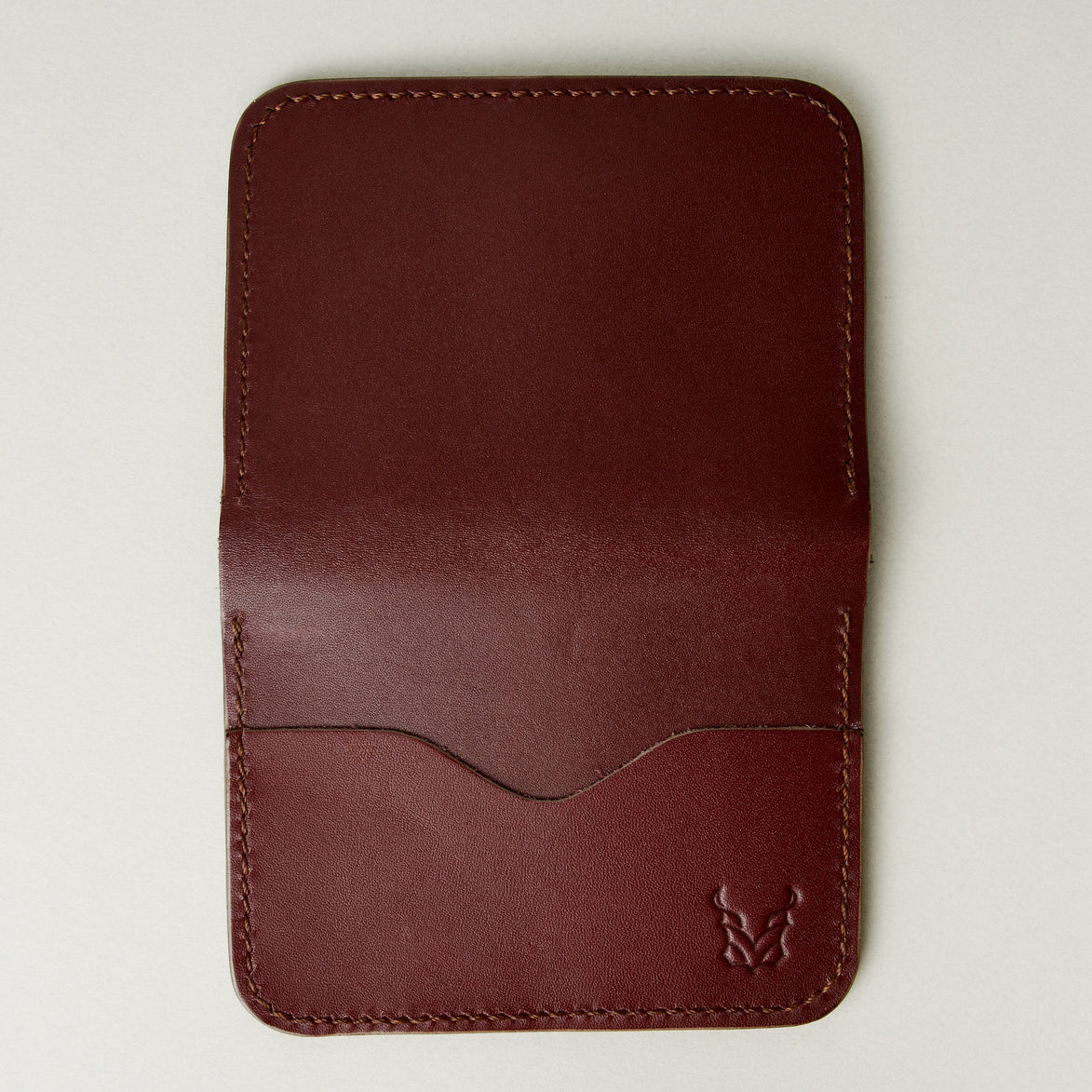 Outside view of espresso brown full-grain leather wallet featuring card slot, handmade stitching and embossed logo. Markore Ravi Slip.