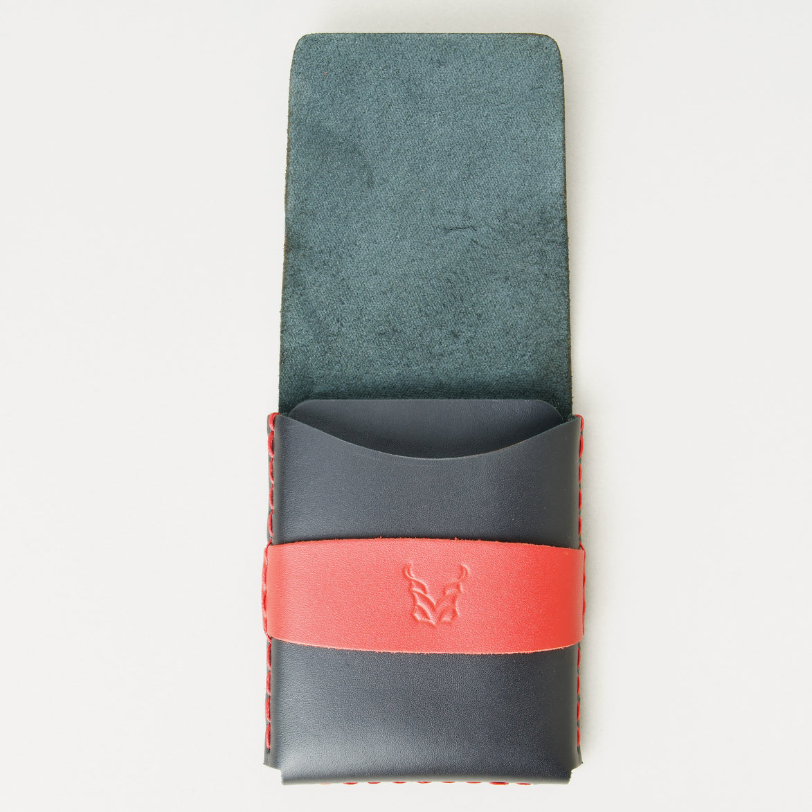 Front view of midnight black full-grain leather flap wallet with open flap, featuring a red flap holder with embossed logo, and red handmade stitching. Markore Sutlej Vault.