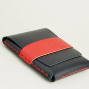Bottom side view of midnight black full-grain leather flap wallet featuring a red flap holder with embossed logo, and red handmade stitching. Markore Sutlej Vault.