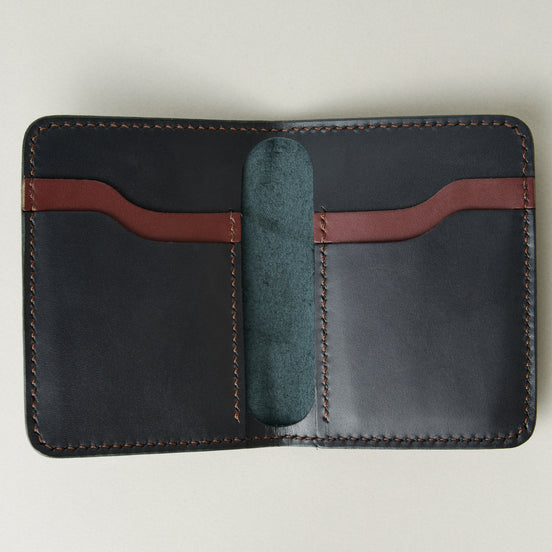 Inside view of midnight black full-grain leather wallet featuring midnight black and espresso brown card slots and espresso brown handmade stitching. Markore Ravi Fold.