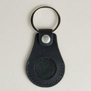 Front view of midnight black AirTag keychain in full-grain leather with round metal key ring and stainless steal press stud. Markore Tag Mate.